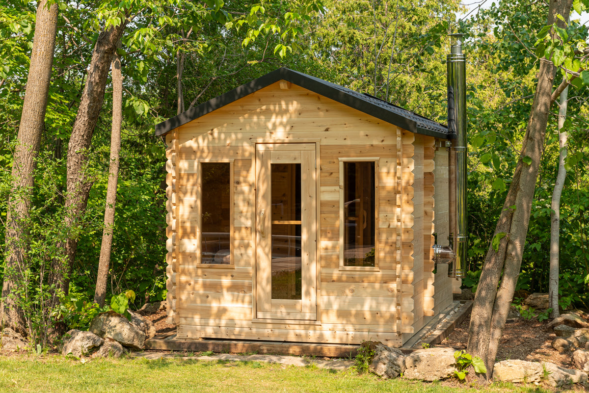 LeisureCraft Georgian cabin sauna front with chimney on the side, set among trees