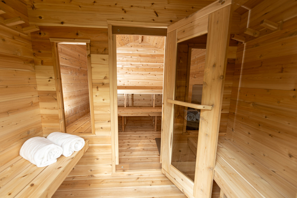 Georgian cabin sauna changeroom with bench and towels, opening into the sauna room